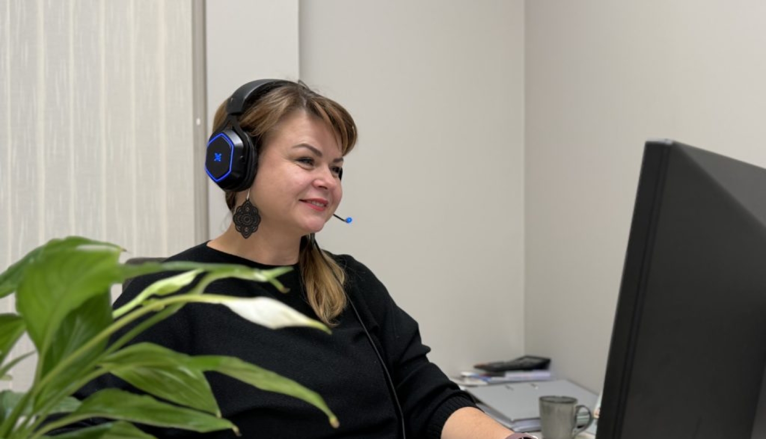 Sieviete sēž pie datora ekrāna, kurā redzama kursu norise.